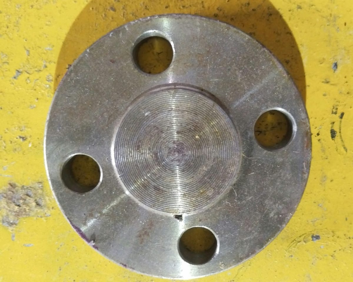 Blind flange with a serrated raised face finish