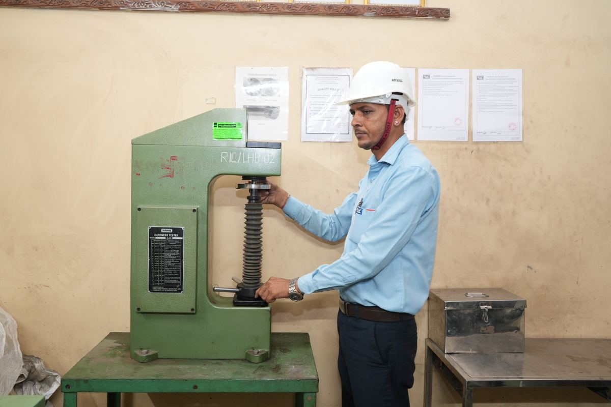 Engineer operating a Rockwell and Brinell hardness tester