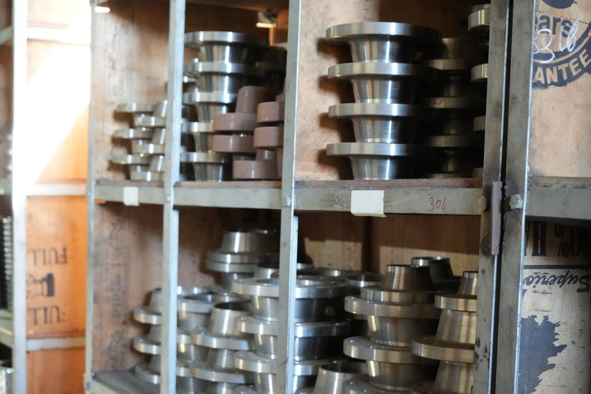 Weld neck flanges of different sizes stored on wooden racks